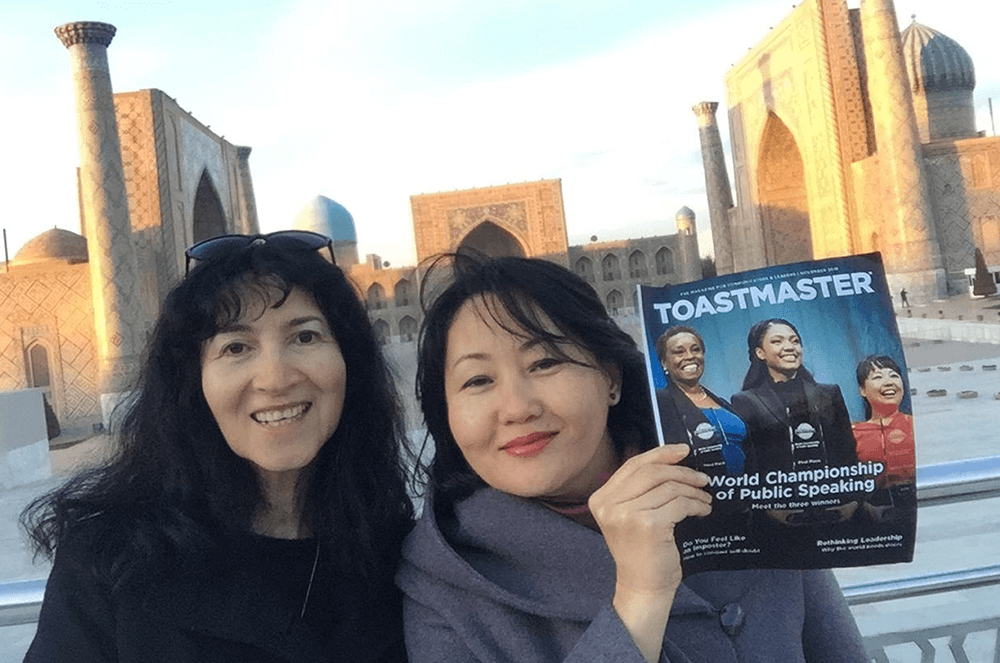 “Two women posing outdoors with magazine