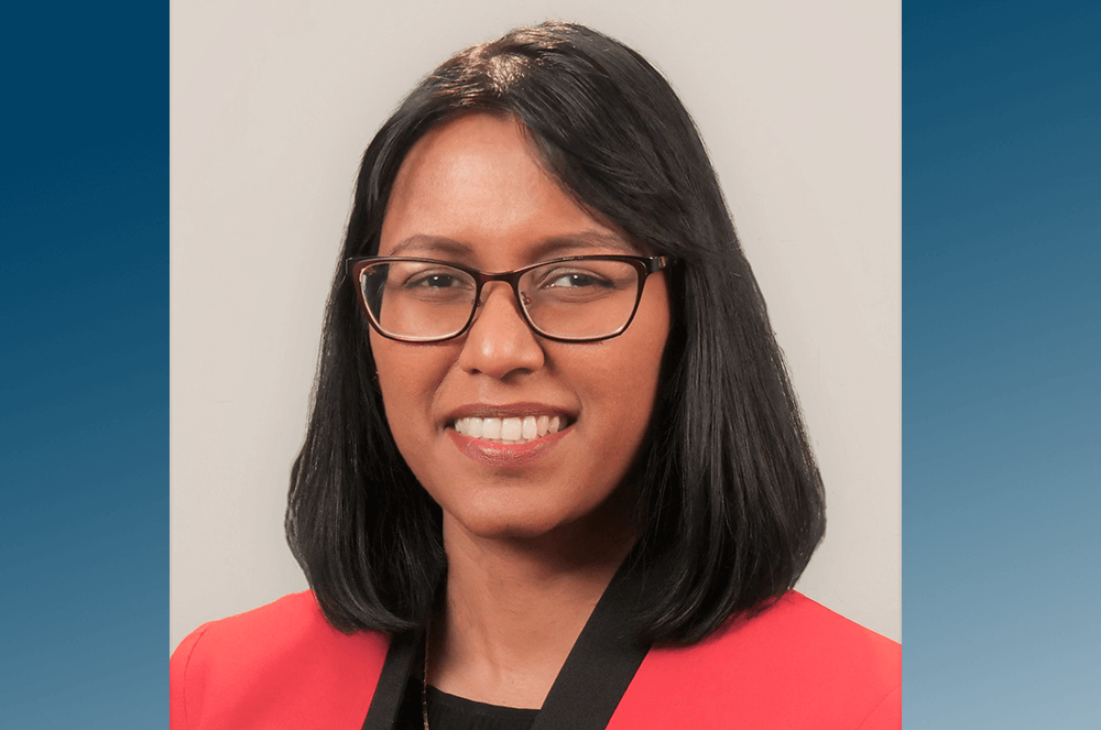 Woman in red jacket and glasses smiling