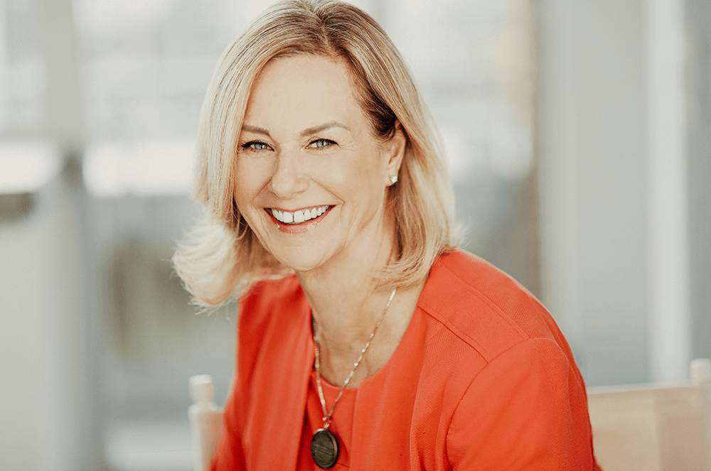 Margaret Page smiling in orange jacket