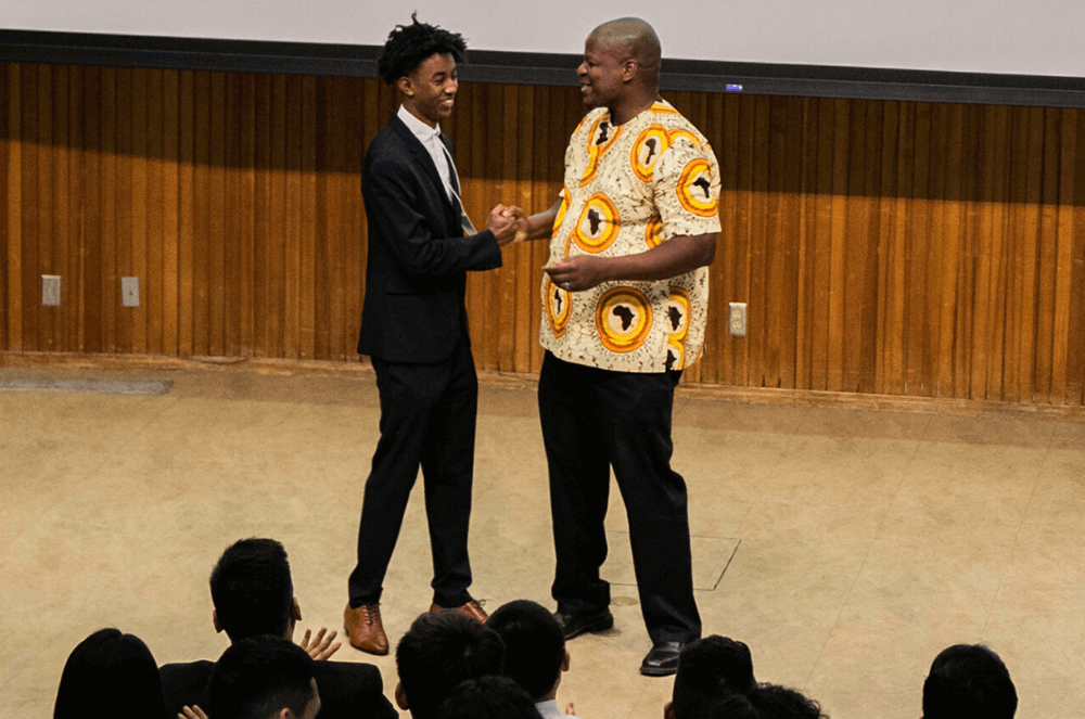 Man shaking hands with someone onstage